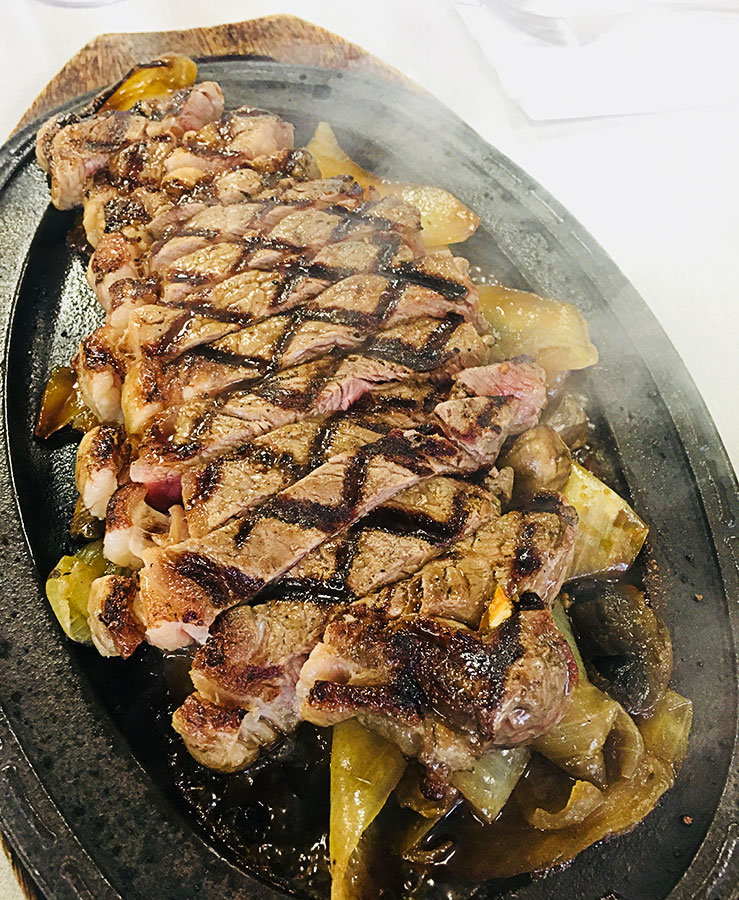 image of sizzling ribeye steak from Restaurant Kenichi